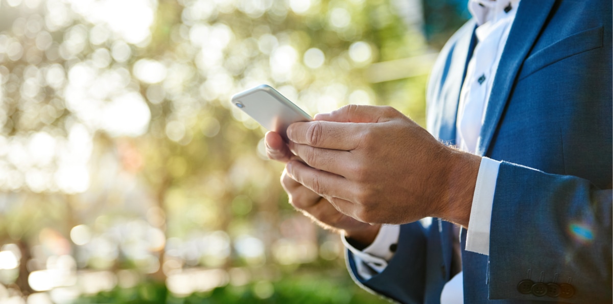 Immobilienverwalter liest die Praxistipps des VDIV Deutschland auf seinem Mobiltelefon